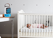 Arctic Air® Polaris+ on a table beside a baby crib while a baby is sleeping